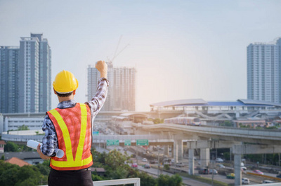 工程師或建筑師與防護(hù)安全帽檢查建筑圖紙呼叫支持團(tuán)隊(duì)在建筑工地。工程建筑和建筑施工理念。軟焦點(diǎn)